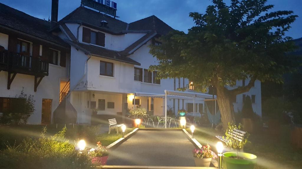 a large white house with a tree in front of it at Hotel Restaurant Le Traineau in Clelles