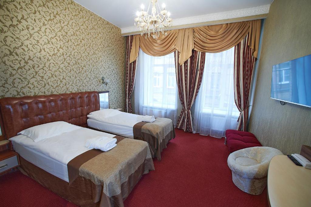 a hotel room with two beds and a chandelier at Никонов отель in Saint Petersburg