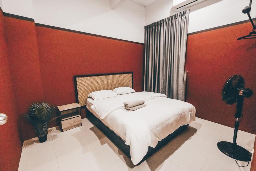 a bedroom with a bed and a red wall at J Residence in Banting