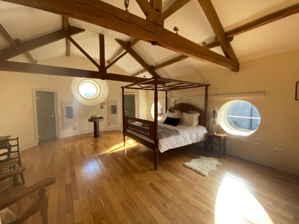 a bedroom with a bed in a room with wooden floors at Glanhenwye Courtyard Cottages in Glasbury