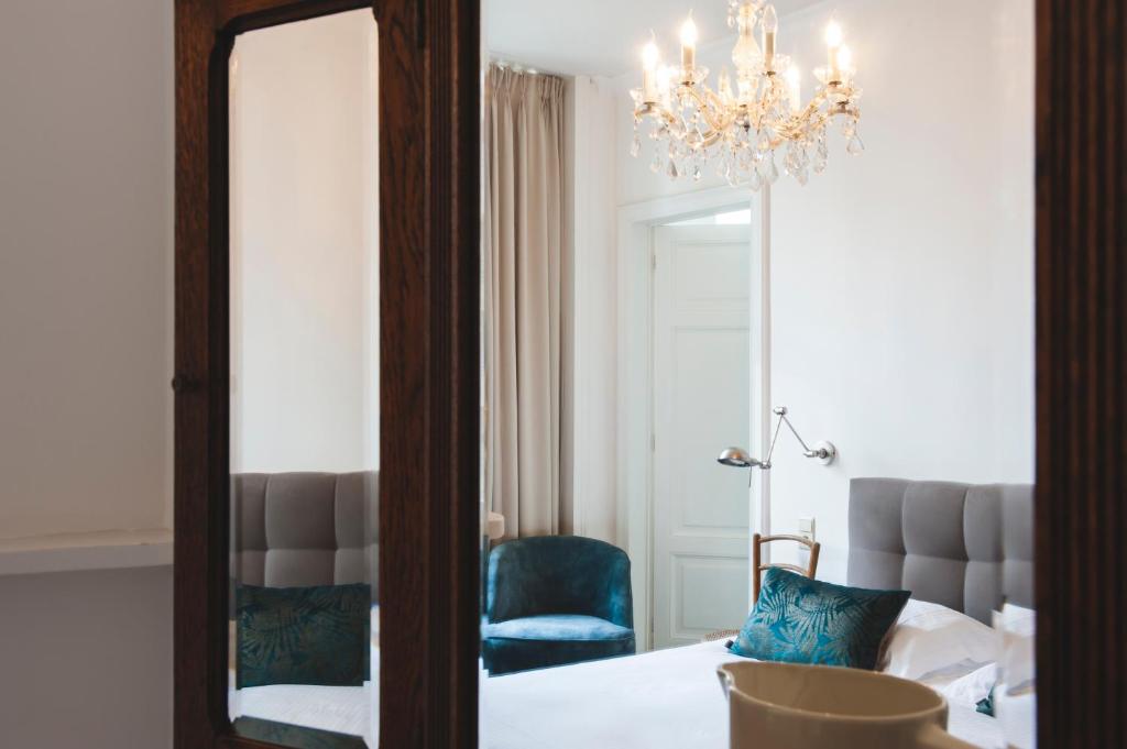 a mirror in a room with a bed and a chandelier at B&B La Passion Interdite in Ostend