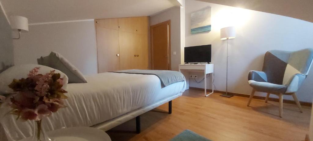 a bedroom with a bed and a desk and a chair at Apartamentos Prestin in Cangas de Onís