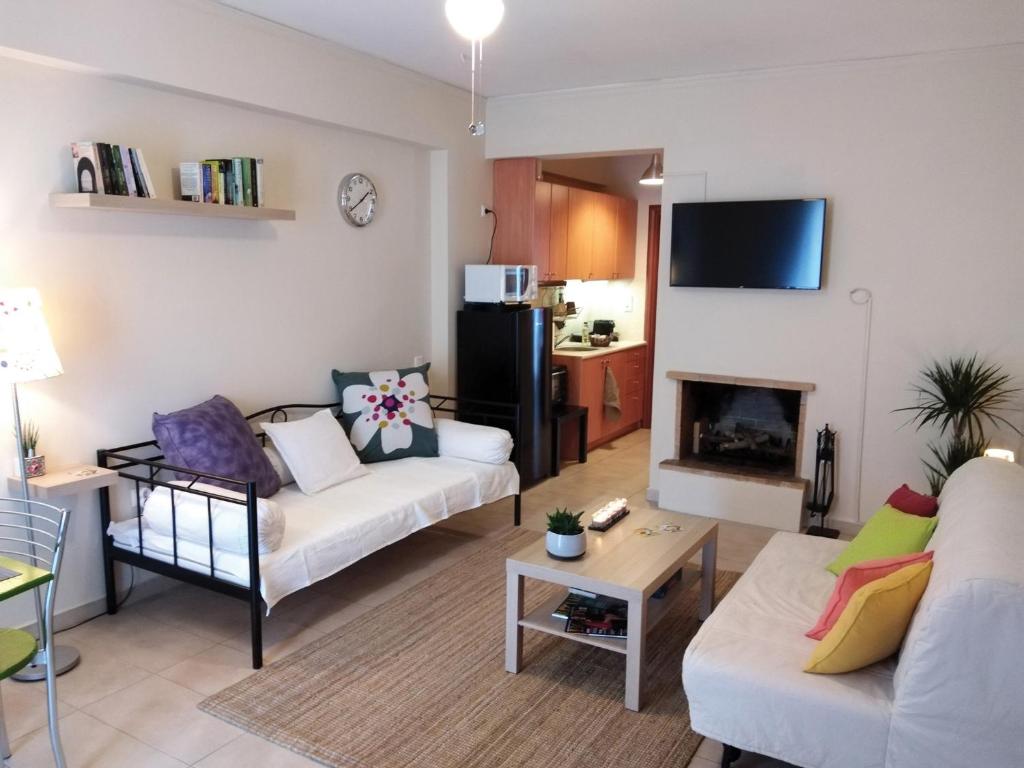 ein Wohnzimmer mit 2 Sofas und einem Kamin in der Unterkunft Aloe apartment in Askeli in Poros