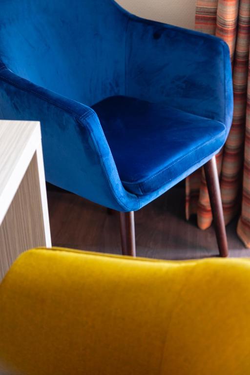 a blue chair sitting next to a yellow couch at Hotel Miramar in Cap d'Ail