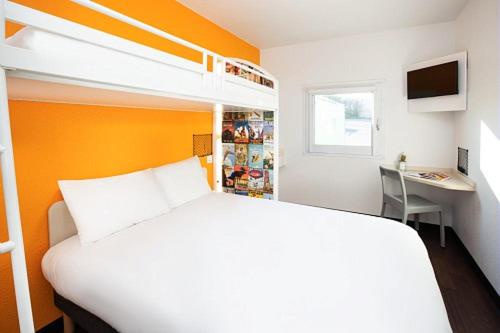 une chambre avec un lit et un bureau avec un ordinateur dans l'établissement hotelF1 Saint Malo, à Saint-Malo
