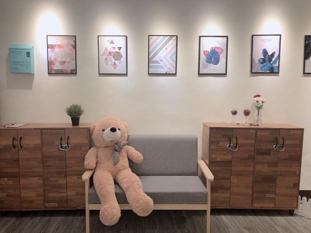 a teddy bear sitting on a chair in a room at Tourism B&B in Hsinchu City