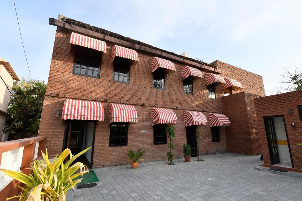 a brick building with red and white awnings on it at Hotel Sunbird in Bharatpur