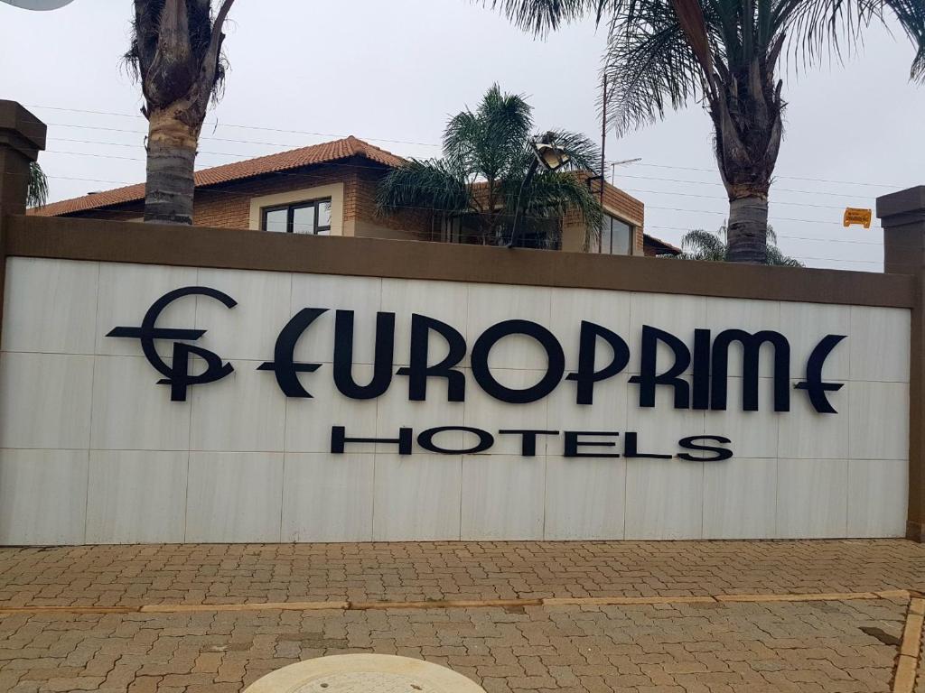 a sign for a hotel with palm trees in the background at Europrime Hotel in Boksburg