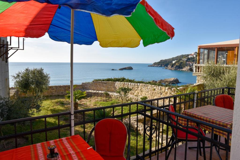 uma varanda com uma mesa e um guarda-chuva em Apartments Susanna em Ulcinj
