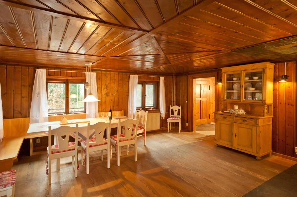 une salle à manger avec un plafond en bois, une table et des chaises dans l'établissement Wald-Ferienhaus-Seefried, à Immenstadt