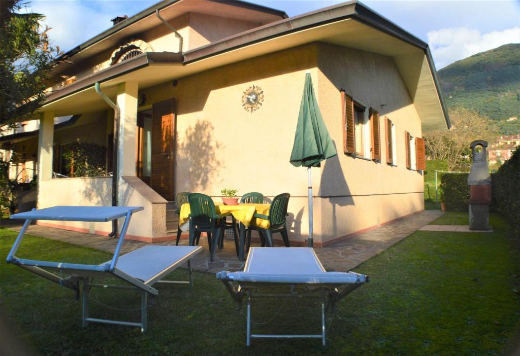 uma casa com cadeiras, uma mesa e um guarda-sol em casa Carla em Camaiore