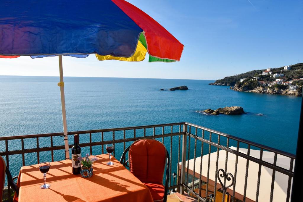 uma mesa com um guarda-sol em uma varanda com vista para o mar em Apartments Susanna em Ulcinj