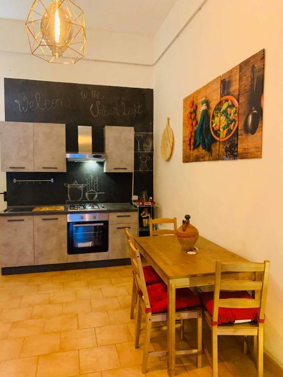 a kitchen with a wooden table with chairs and a dining room at Urban loft in Manciano