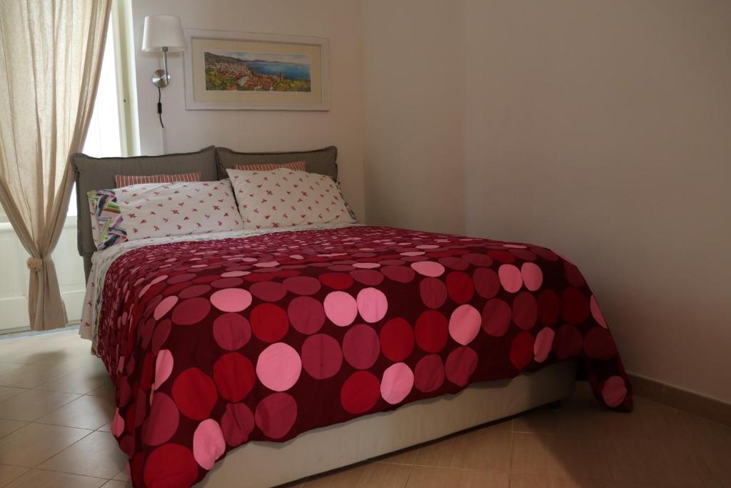 サレルノにあるArcadia 55のベッドルーム1室(赤とピンクの掛け布団付きのベッド1台付)