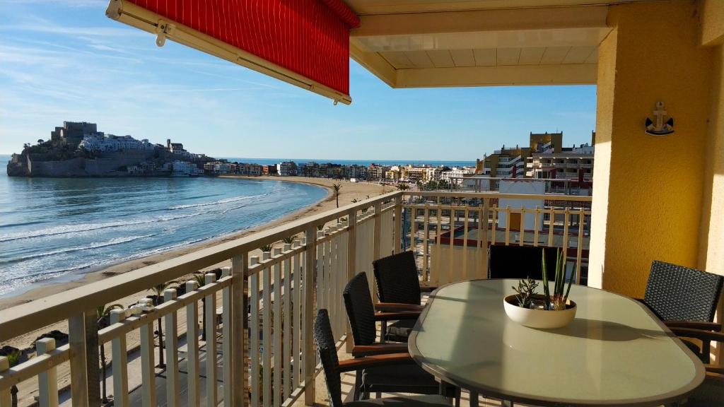 a table on a balcony with a view of the beach at Torre Hirta 1 in Peniscola