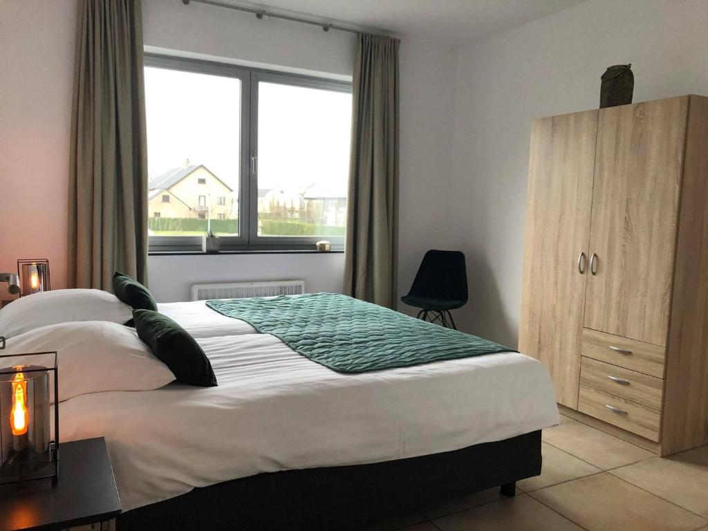 una camera con un grande letto e una finestra di Apartment Fruithof Tack a Sint-Gillis-Waas