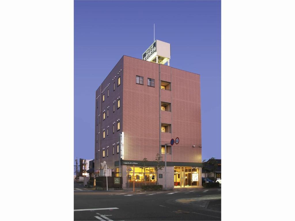 藤枝市にあるFujieda Ogawa Hotel フジエダオガワホテルの通りに窓のある茶色の高い建物