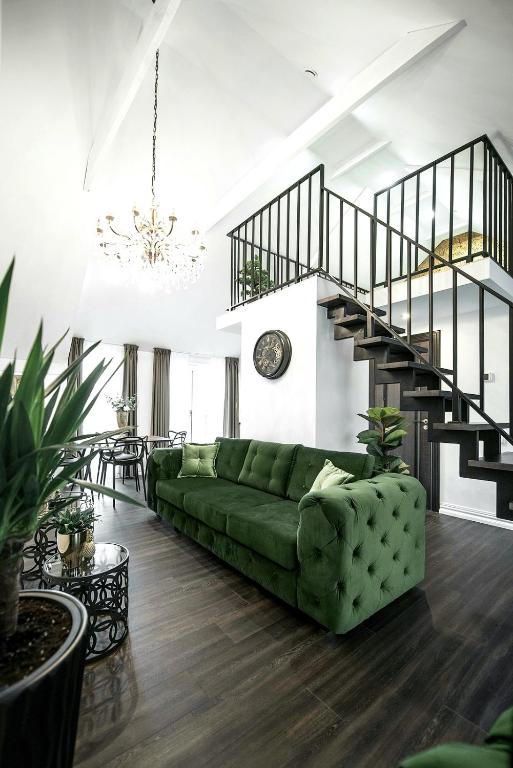 sala de estar con sofá verde y escalera en Luxury Loft, en Kaunas