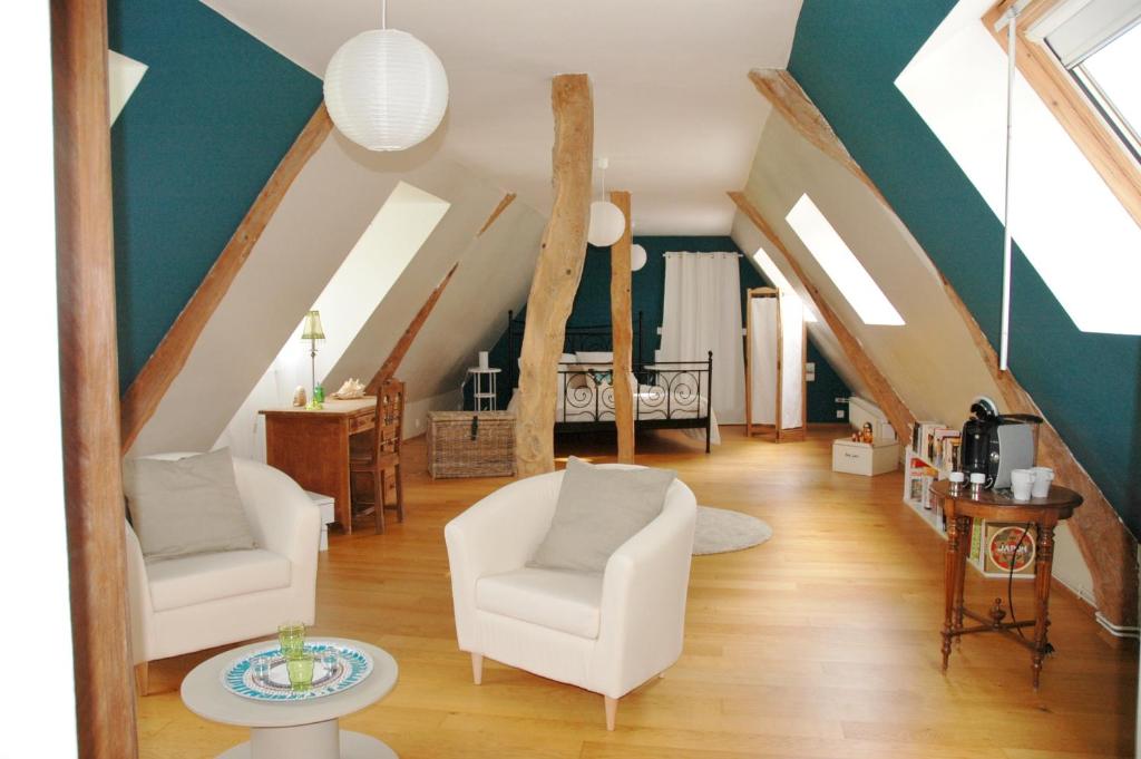 ein Wohnzimmer mit weißen Stühlen und einer Treppe in der Unterkunft Les Hortensias-chambre chez l'habitant in Bretteville-du-Grand Caux