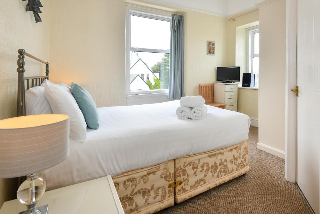 a bedroom with a large bed with a window at The Wylfa in Abersoch