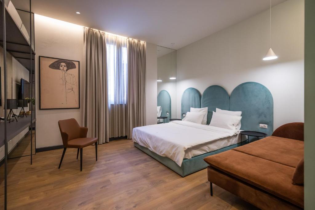 una camera d'albergo con letto e sedia di Allure Boutique Hotel a Tirana