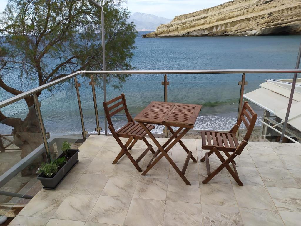 - une table et deux chaises sur un balcon avec eau dans l'établissement Studio Kostas, à Matala