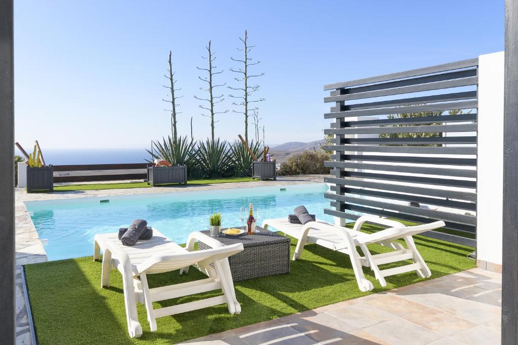 a patio with two chairs and a swimming pool at Casa Amanecer II in Mácher