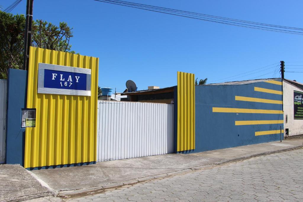 uma parede amarela e azul com um sinal em Pousada Flay 7 minutos do Aeroporto Florianópolis em Florianópolis
