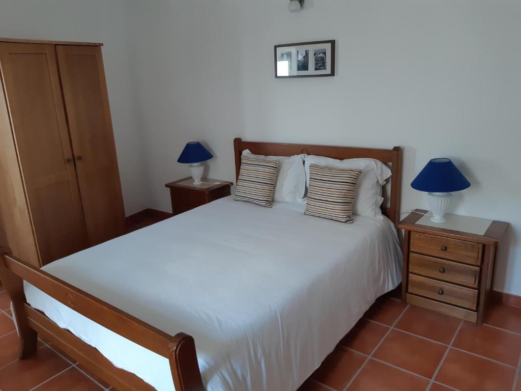 a bedroom with a large white bed with two lamps at Casa Azul in Avis