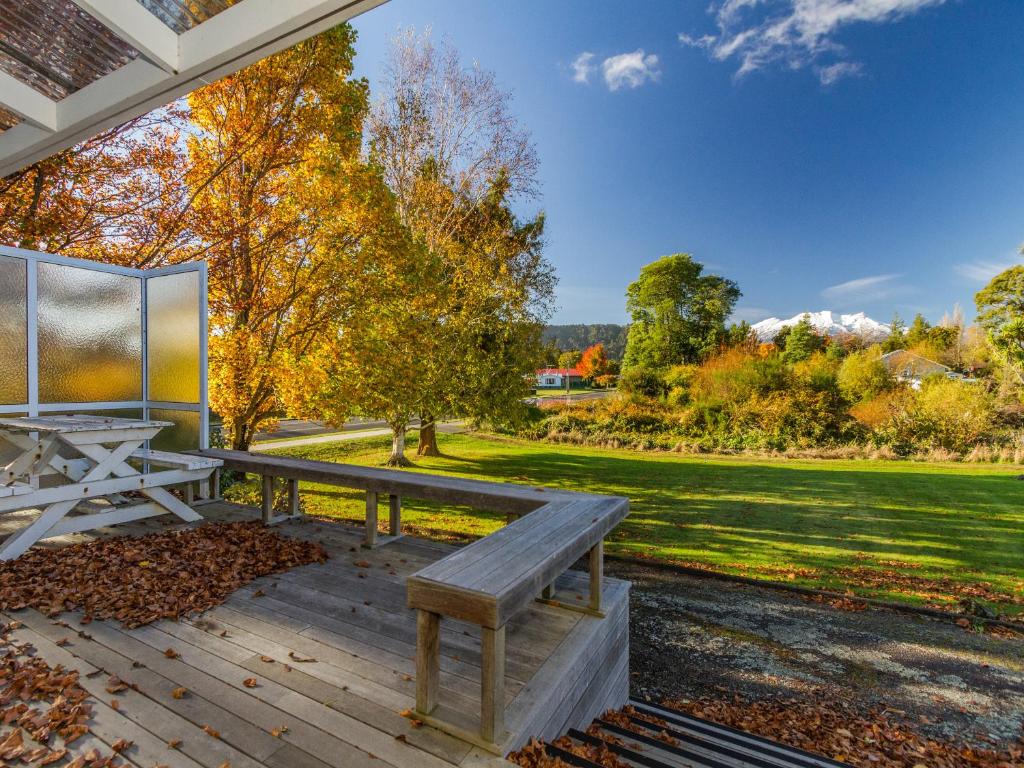 a picnic table and bench on a wooden deck at Kune Crib - Ohakune Holiday Home near Turoa in Ohakune