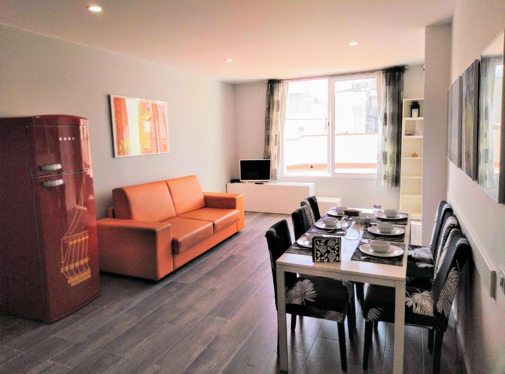 sala de estar con sofá, mesa y sillas en Apartamentos Turísticos Tenor by Bossh Hotels en Barcelona
