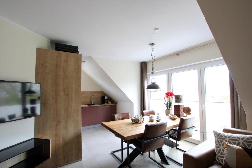 a kitchen and dining room with a table and chairs at Landblick 2 in Norddeich