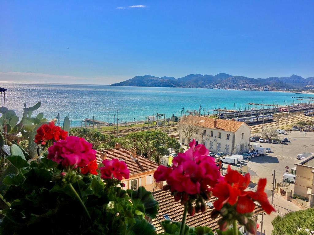 a view of the ocean from a building with flowers at MyHome Riviera - Cannes Sea View Apartment Rentals in Cannes