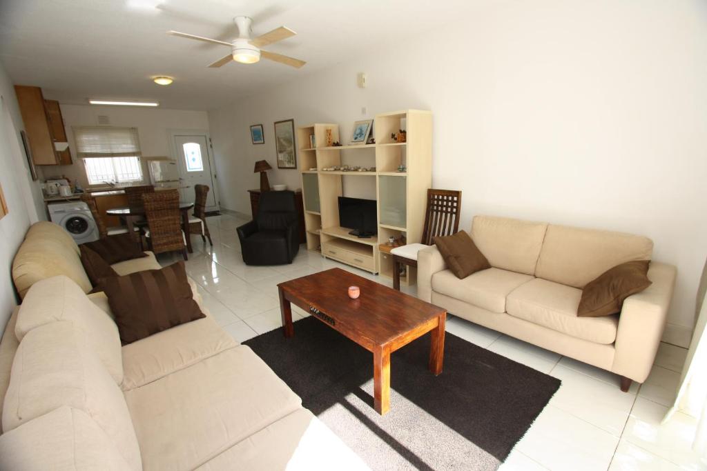 a living room with two couches and a coffee table at Pissouri Beach Apartments in Pissouri