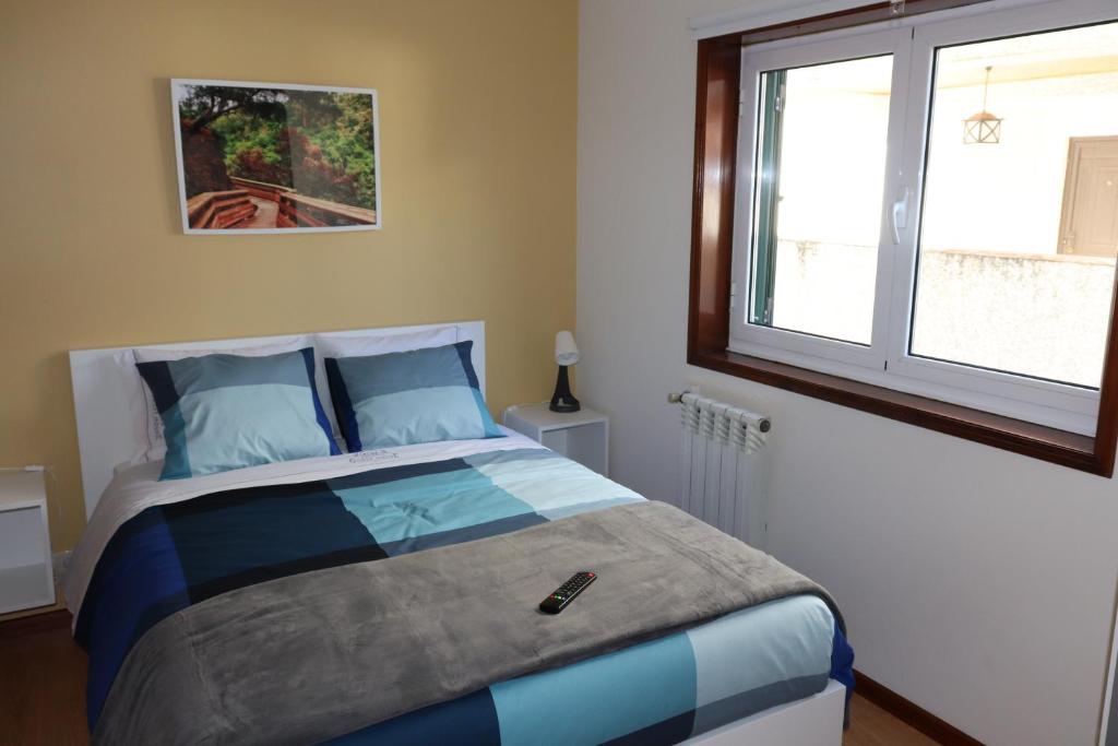 um quarto com uma cama com almofadas azuis e uma janela em Arouca Guest House em Arouca