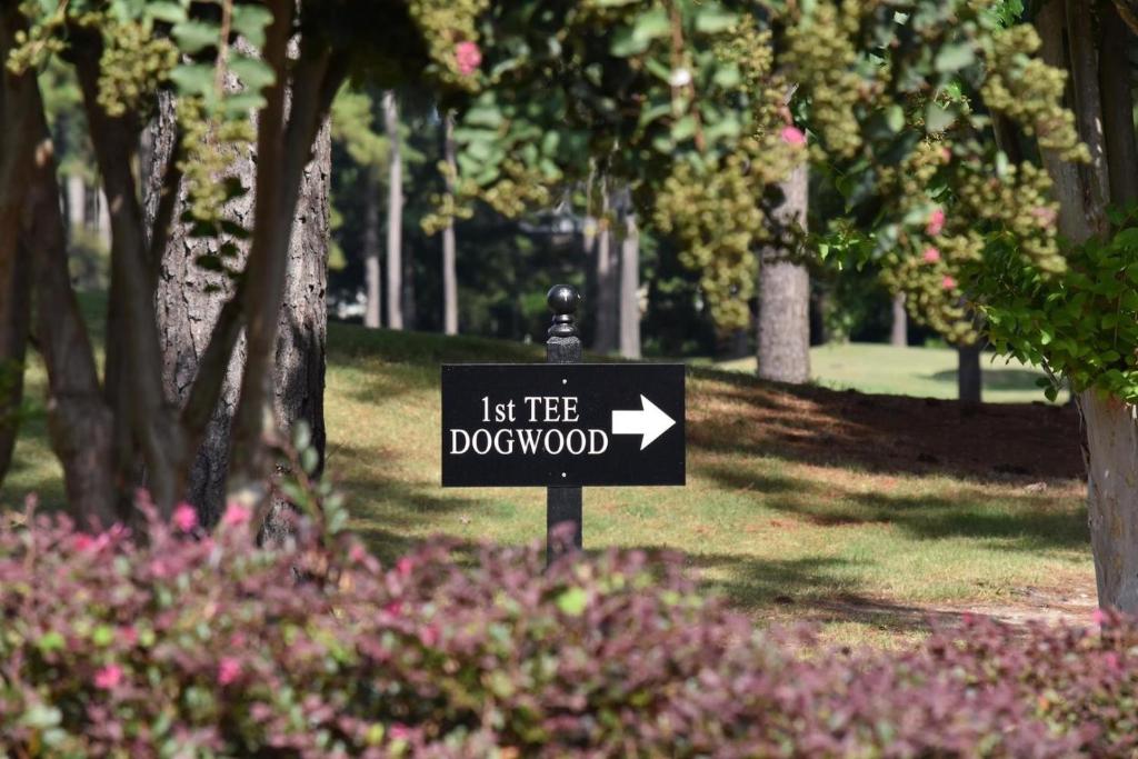 een bord in een park met een laat de hond poepen bord bij Pool View Villa 1504 with Golf Course in Calabash