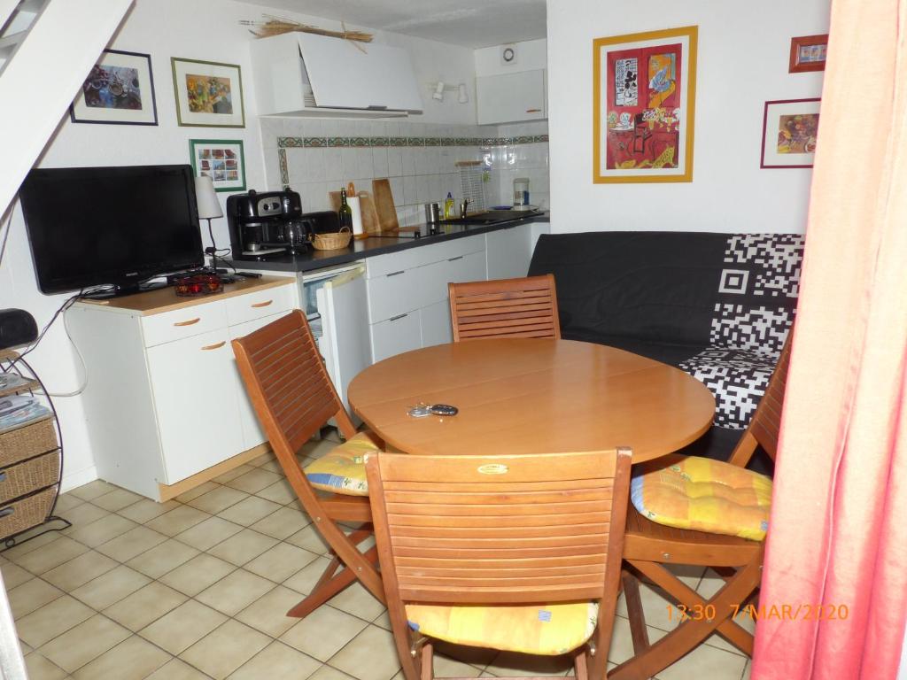 een keuken en eetkamer met een tafel en stoelen bij Gênois 1 in Hourtin