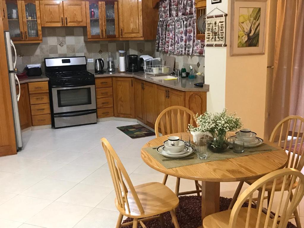 a kitchen with a wooden table and chairs and a kitchen with a stove at Glynver Apartments in Christ Church