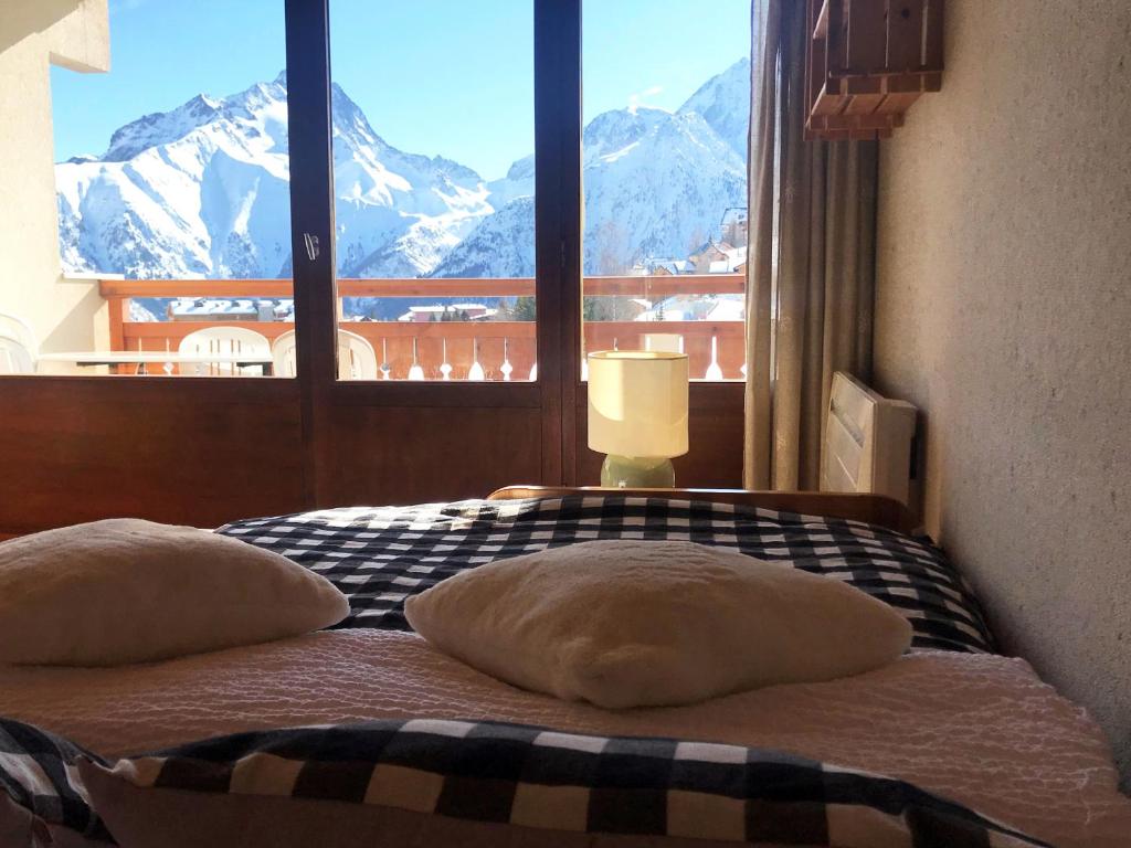 a bedroom with a bed with a view of mountains at Résidence L’Etendard in Les Deux Alpes