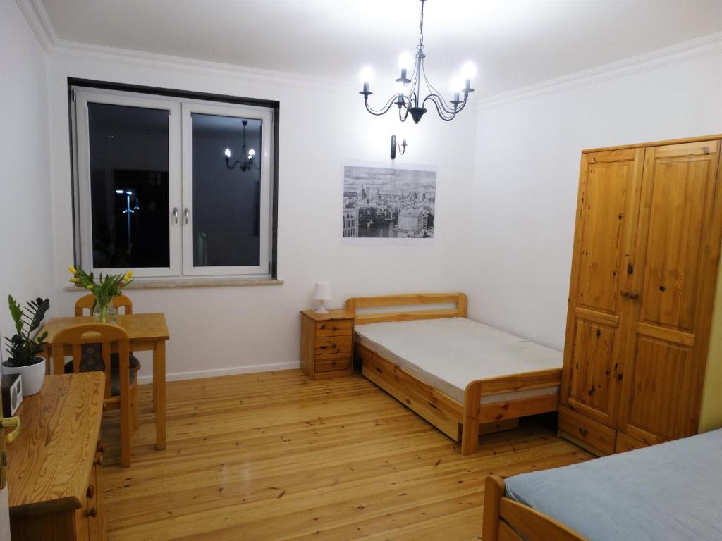 グダニスクにあるDuże Pokoje Gdańsk Głownyのベッドルーム1室(ベッド1台、テーブル、窓付)