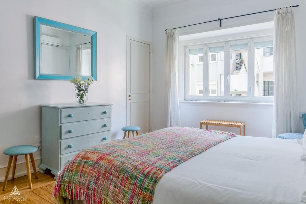 a bedroom with a bed and a dresser and a window at Casa da Avenida Lisboa in Lisbon