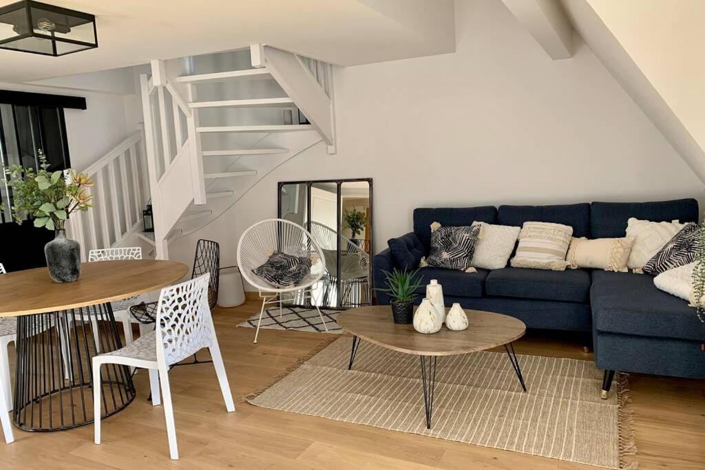 sala de estar con sofá azul y mesa en LA BAULE - COUP DE CŒUR – T3 - Tout à Pied en La Baule