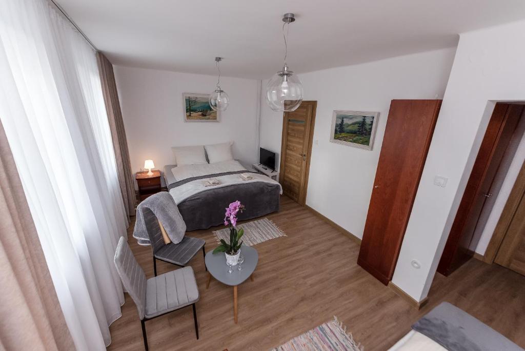 Un dormitorio con una cama y una mesa con flores. en Willa Biały Domek, en Ustroń