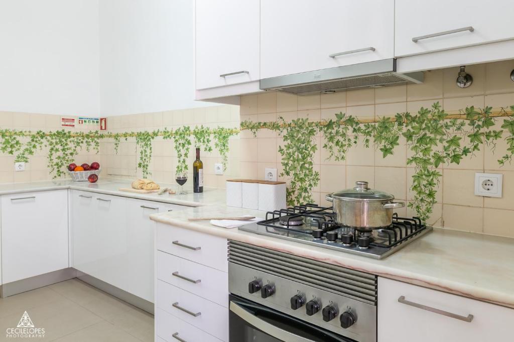 a kitchen with white cabinets and a pot on the stove at Casa da Avenida Lisboa in Lisbon