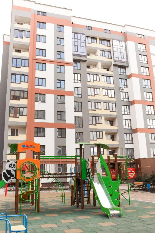 a playground in front of a large building at Style Стильні апартаменти в ЖК "Варшавський" біля парку in Ternopilʼ