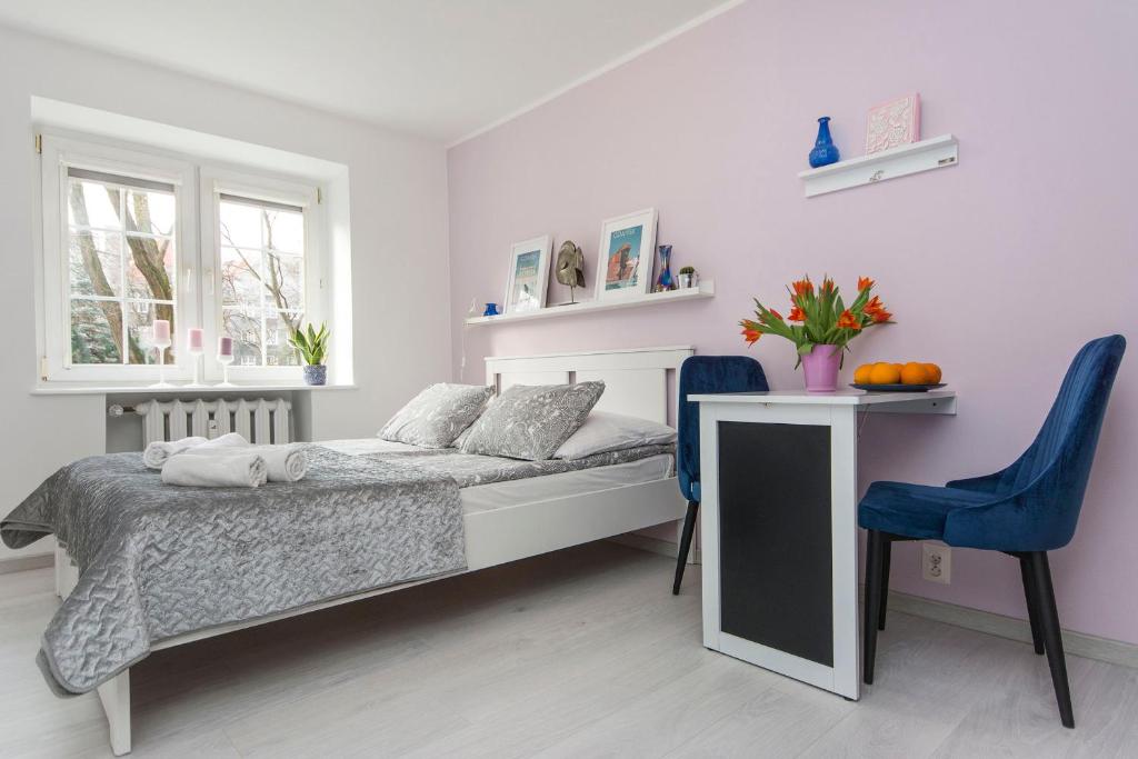 a bedroom with a bed and a table and chairs at RentApart Stare Miasto in Gdańsk