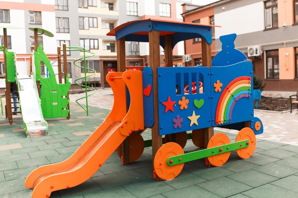 a toy train on a playground with a slide at Style Стильні апартаменти в ЖК "Варшавський" біля парку in Ternopilʼ
