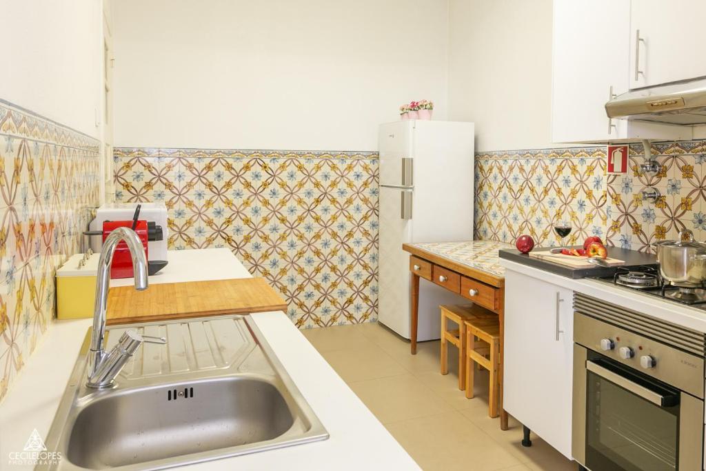 a kitchen with a sink and a refrigerator at Casa da Avenida Lisboa in Lisbon