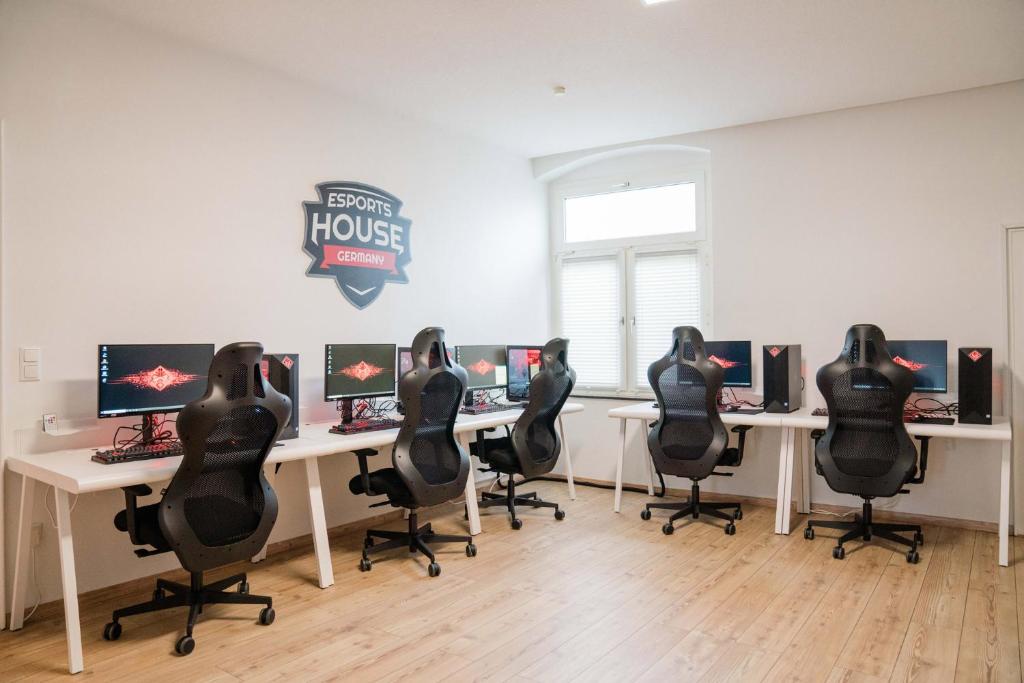 Pokój z 4 biurkami z krzesłami i komputerami w obiekcie esports house Germany w mieście Gladbeck