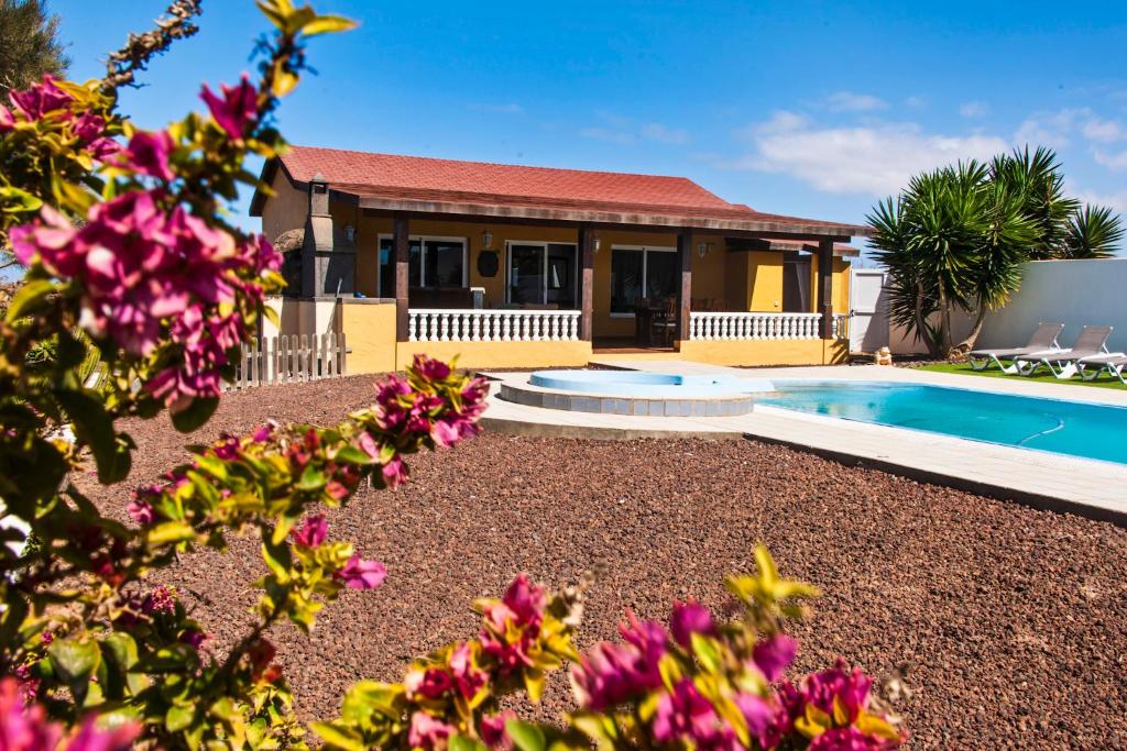 a house with a swimming pool and flowers at VISTAMALPEI in Cotillo